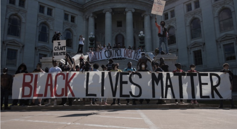 Protestors in front of the Wisconsin State Capitol in Madison holding a large banner reading "Black Lives Matter"